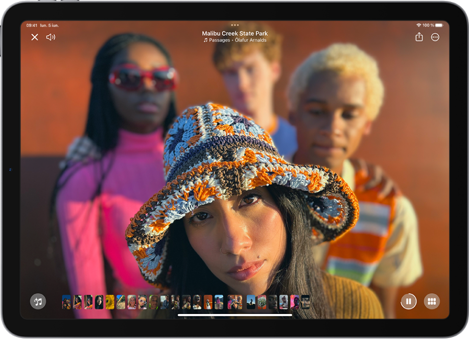 O amintire este în redare în mijlocul ecranului. În partea de jos a ecranului, de la stânga la dreapta, se află butonul Mixaje amintiri, miniaturile pozelor din amintire și butoanele Suspendați și Explorați. În partea de sus a ecranului se află butoanele Închideți și Volum. În partea de sus a ecranului se află butoanele Partajați și Mai multe.