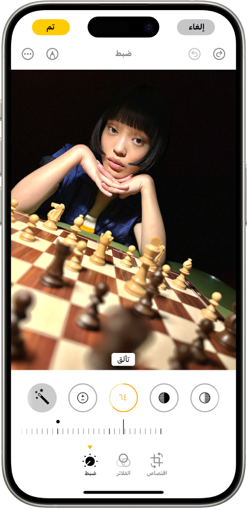 شاشة تعديل مع عرض صورة في المنتصف. في الجزء السفلي من الشاشة، من اليمين إلى اليسار، تظهر أزرار الضبط والفلاتر والاقتصاص. زر تعديل محدد ويظهر شريط تمرير لضبط درجة التألق. زر الإلغاء يظهر في الزاوية العلوية اليمنى من الشاشة، ويظهر زر تم في الزاوية العلوية اليسرى.