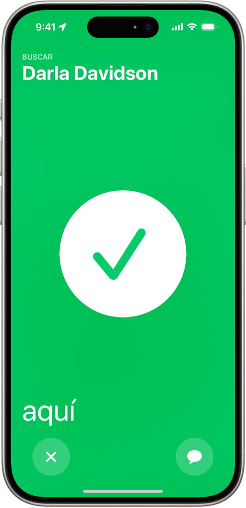 La pantalla del iPhone en color verde mostrando una gran marca de verificación en el centro. El nombre de la persona que se está localizando está en la esquina superior izquierda, y en la esquina inferior izquierda aparece la palabra “aquí”, indicando que se encontró correctamente.