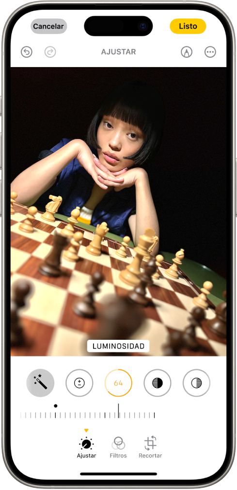 La pantalla Editar con una foto en el centro. En la parte inferior de la pantalla, de izquierda a derecha, se encuentran los botones Ajustar, Filtros y Recortar. Se selecciona el botón Ajustar y se muestra un regulador para ajustar el brillo de la foto. El botón Cancelar está en la esquina superior izquierda de la pantalla, y el botón Listo está en la esquina superior derecha.