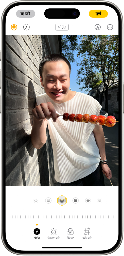 किसी पोर्ट्रेट की “संपादित करें” स्क्रीन। तस्वीर स्क्रीन के मध्य में मौजूद है और तस्वीर के नीचे पोर्ट्रेट लाइटिंग विकल्प हैं। स्टूडियो लाइट को चुना गया है। उसके नीचे प्रभाव के स्तर को ऐडजस्ट करने के लिए एक स्लाइडर है। स्क्रीन पर सबसे नीचे बाएँ से दाएँ, पोर्ट्रेट, ऐडजस्ट करें, फ़िल्टर और क्रॉप करें बटन हैं। पोर्ट्रेट बटन चुना गया है।