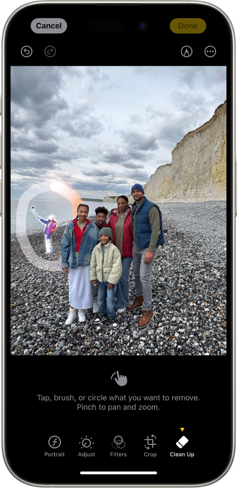 iPhone wyświetlający edytowane zdjęcie w aplikacji Zdjęcia. Postać w tle zdjęcia jest wyróżniona otaczającym ją okręgiem.