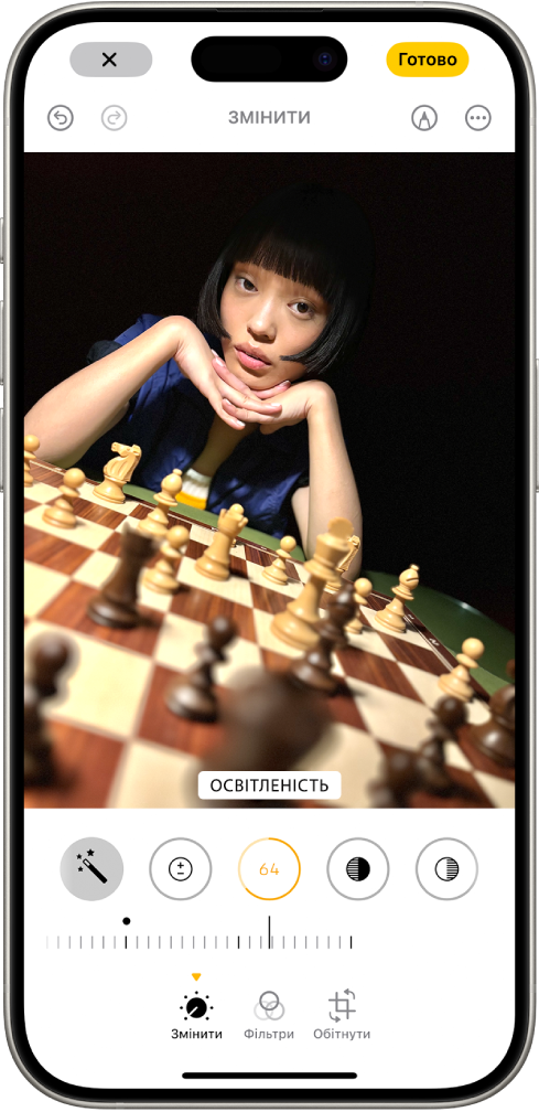 Екран «Редагувати» з фотографією в центрі. Унизу екрана зліва направо розташовані кнопки «Налаштувати», «Фільтри» та «Обітнути». Вибрано кнопку «Корекція» і показано повзунок для корекції параметра «Освітленість». Кнопка «Скасувати» розташована у верхньому лівому куті екрана, а кнопка «Готово» — у верхньому правому куті.