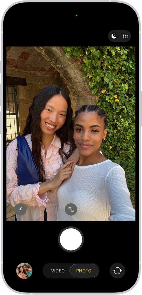 Der Bildschirm „Kamera“ im Modus „Foto“. Im Kamerarahmen sind Personen sichtbar, die ein Selfie machen.