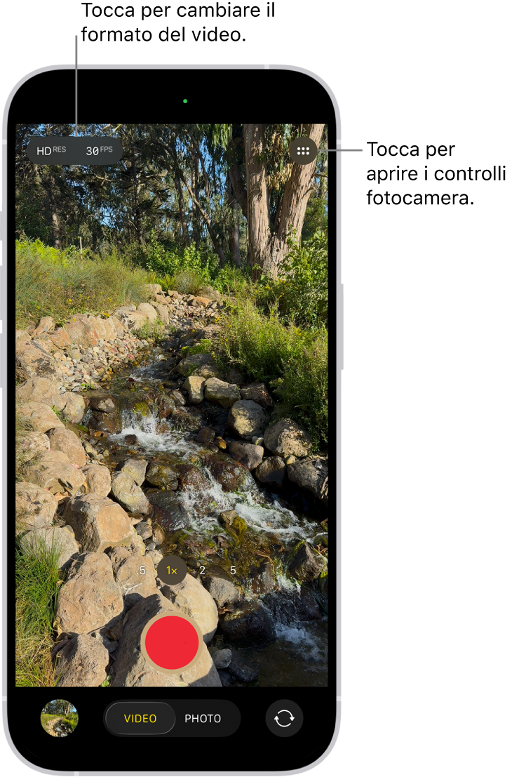 La fotocamera in modalità Video. Il pulsante di controlli della fotocamera si trova nell’angolo alto a destra, mentre il pulsante del formato video ideo si trova nell’angolo in alto a sinistra. Il pulsante del visore di foto e video si trova nell’angolo inferiore sinistro. Il pulsante Registra è posizionato in basso al centro e il pulsante per scegliere la fotocamera posteriore si trova nell’angolo inferiore destro.