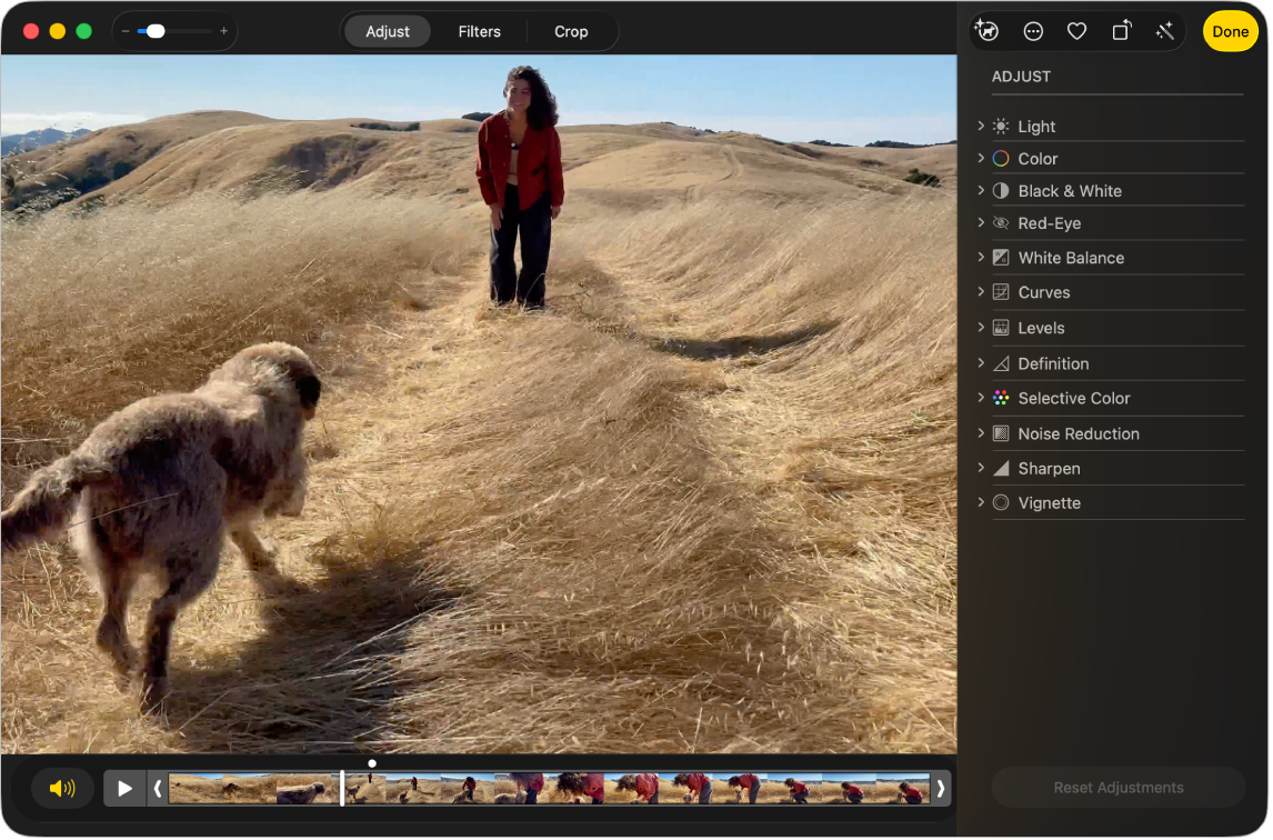 Ein Video in der Bearbeitungsansicht mit einem Regler darunter, der die Bilder des Videos zeigt. Die Tasten „Lautsprecher“ und „Wiedergabe“ befinden sich links neben dem Regler; rechts davon erscheinen die Anpassungswerkzeuge.