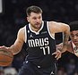 Dallas Mavericks guard Luka Doncic, left, drives the lane around New York Knicks guard Quentin Grimes, center, during the first quarter of an NBA basketball game, Saturday, Dec. 3, 2022, in New York. (AP Photo/Bebeto Matthews)