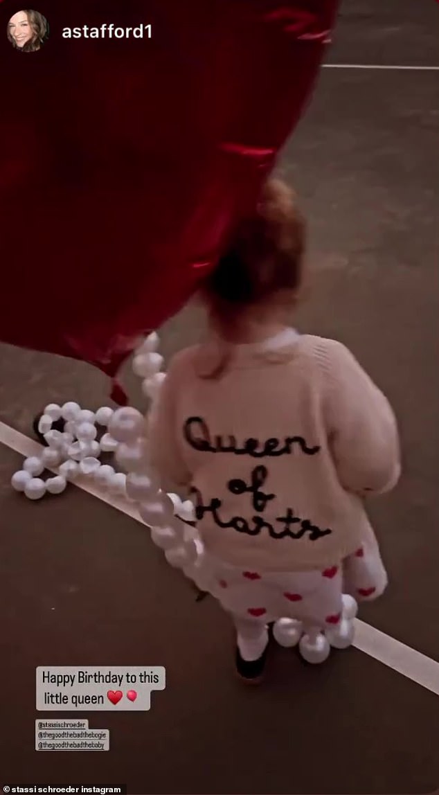 The Queen: Hartford declared she's the 'Queen of Hearts' by wearing a cute white sweater with her red heart dress and black shoes