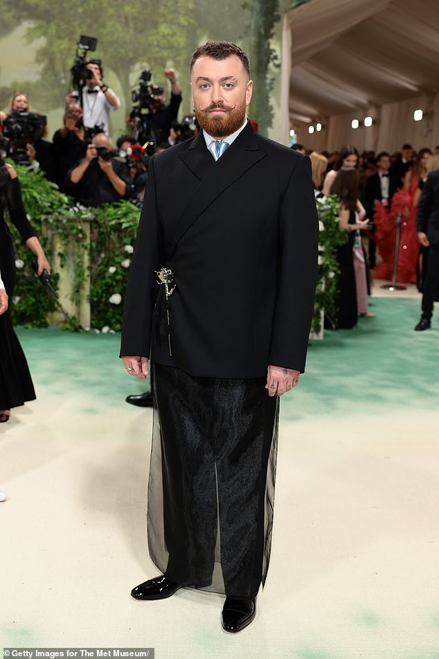 The Grammy winner added a collared white shirt underneath with a baby blue satin tie, and gave their look an androgynous element with a sheer skirt