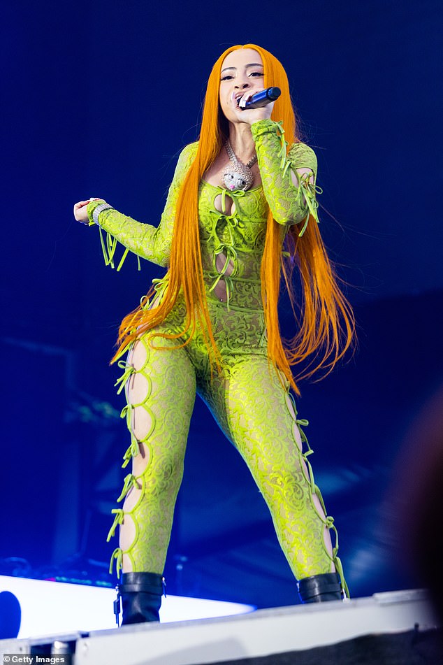 She wore a sizzling sheer green lace bodysuit with a pin-straight tangerine wig reaching down to her thighs; seen Sunday in Vienna