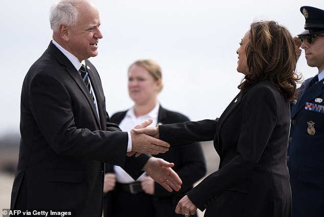 Minnesota Governor Tim Walz (L) greets Vice President Kamala Harris as she arrives at the Minneapolis-St. Paul International Airport