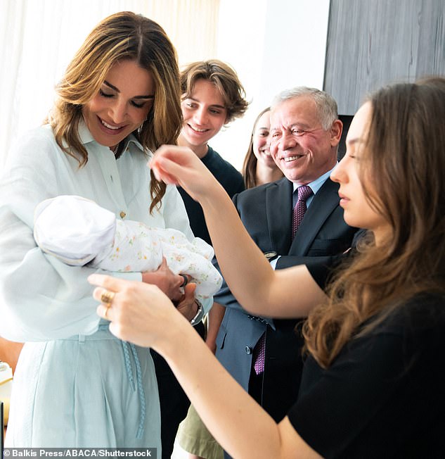 Queen Rania is pictured holding her first grandchild, Princess Iman