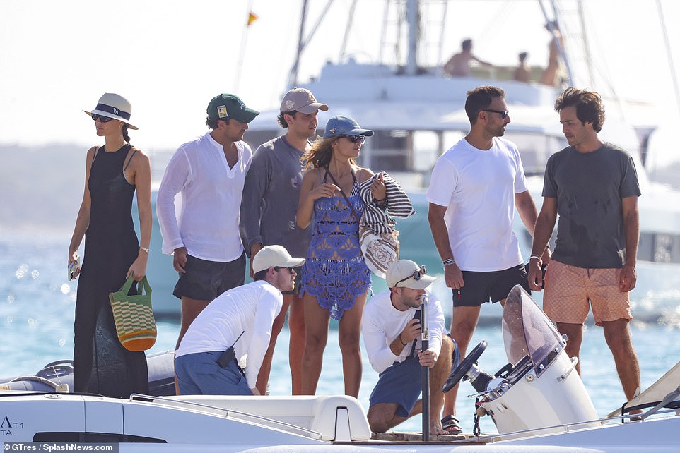 The Italian fashion model, who has participated in 400 fashion shows and graced the cover of Vogue, completed her beachy look with a wrist full of bangles, a denim baseball cap, a brown crossbody purse and sunglasses