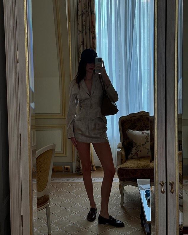 In what appeared to be the same luxurious hotel room, she also shared a mirror selfie she took to showcase her chic outfit for a day of watching equestrian events at this year's Olympics. The model wore a plunging, linen blazer with a matching mini skirt and dark brown oxfords