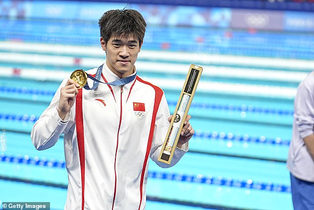 Pan Zhanle shows off his gold medal after winning the men's 100m freestyle. He smashed his own world record by four-tenths of a second with a time of 46.40 seconds