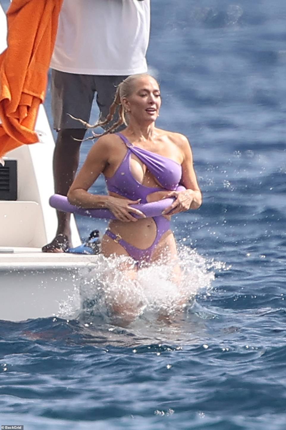 The XXPEN$IVE hitmaker wore a purple monokini that bared her lean midriff as she clung onto a pool noodle to stay afloat