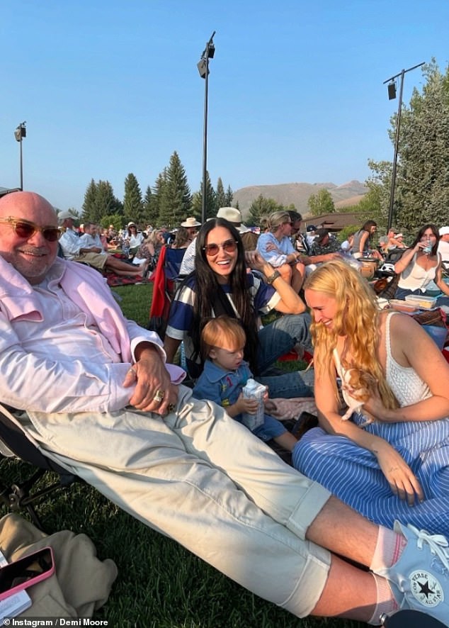 Moore was pictured relaxing in a lawn chair with her daughter and a family friend