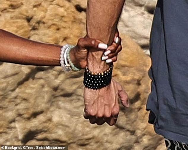 Naomi was seen holding on to Mohammed's wrist to steady herself along the slippery path