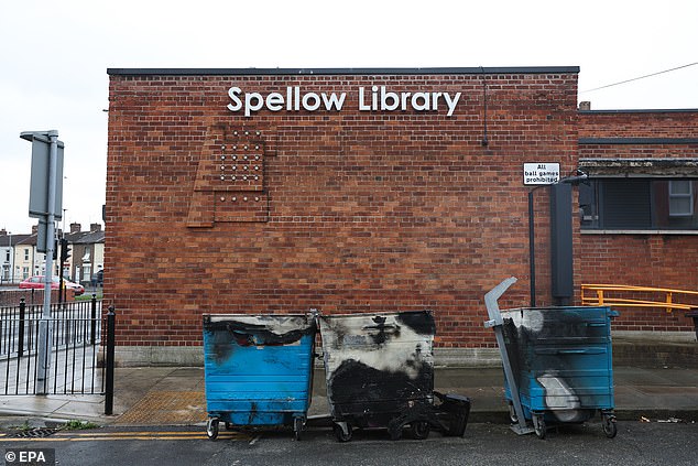 Burnt wheelie bins outside the Spellow Library in Liverpool, which was torched by thugs