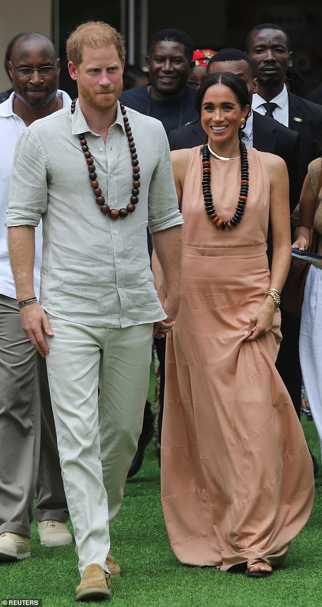 Prince Harry and Meghan walk out after meeting the students at the Lightway Academy in Abuja, Nigeria on May 10,