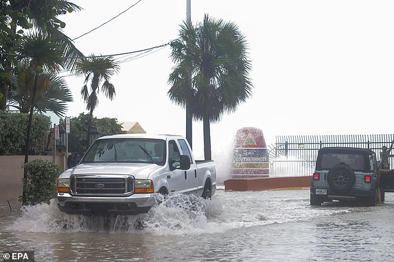 epa11626508 Motorists brave a flooded street due to storm surge and high winds of Hurricane Helene near the 'Southernmost Point' buoy in Key West, Florida, USA, 26 September 2024. Hurricane Helene is strengthening as it moves toward the US Gulf Coast becoming a Category 1 hurricane and is expected to hit Florida's Big Bend later in the day as a Category 4 storm. Around 32 million people are under flood watches from South Florida to southern Virginia.  EPA/SCOTT HALLERAN