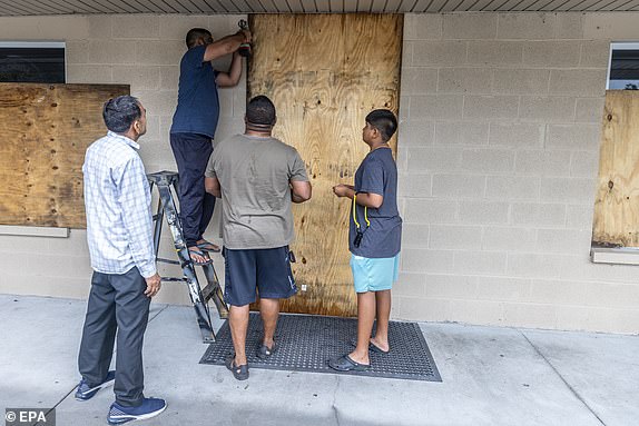 epa11626599 People cover windows with plywood as the town prepares for Hurricane Helene in Mayo, Florida, USA, 26 September 2024. Hurricane Helene is strengthening as it moves toward the U.S. Gulf Coast becoming a Category 1 hurricane and is expected to hit Florida's Big Bend late today as Category 4 storm. Around 32 million people are under flood watches.  EPA/CRISTOBAL HERRERA-ULASHKEVICH