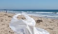 A white plastic bag on a beach with the sea behind