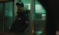 a saudi man in a baseball cap viewed from a car at night in green light