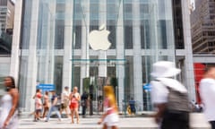 people walk around glass building with white apple sign