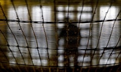 A view from below of a prisoner at HMP Pentonville walking through an atrium