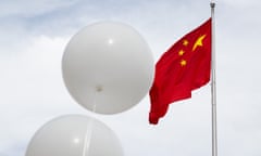 Two white balloons float in front of Chinese flag at the Chinese embassy in Washington DC