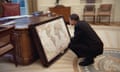 barack obama in the oval office looking at an old map of the world