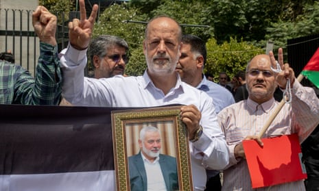 Members of Tehran University Council attend a protest to condemn the killing of Hamas leader Ismail Haniyeh, as they carry Iranian and Palestinian flags at Tehran University, on Wednesday.