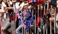 Hands holding Australian flags between fence railings