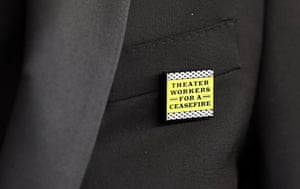 A theatre worker wears a 'ceasefire' pin