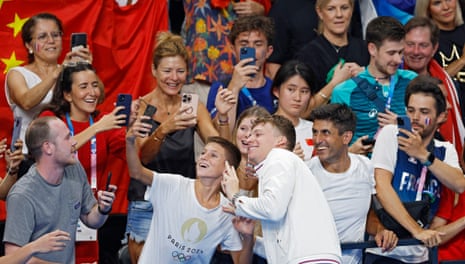 Gold medallist Leon Marchand of France poses for photos after the men’s 200m breaststroke final.