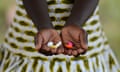 A woman holds out five coloured pills in her upturned palms