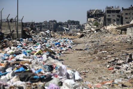 Piles of garbage in Gaza among ruined buildings.