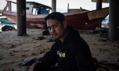 Nasrudin Yahya under a pier with a boat in the background