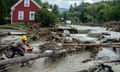 person uses chainsaw on tree amid flooded area