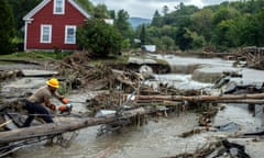 person uses chainsaw on tree amid flooded area