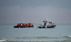 People crowded on to a dinghy, with a French official vessel nearby