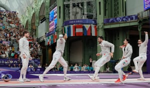 Eli Dershwitz (left) of the USA looks dejected as Ali Pakdaman (centre) and his Iranian teammates celebrate their victory in the men’s sabre team table of eight competition