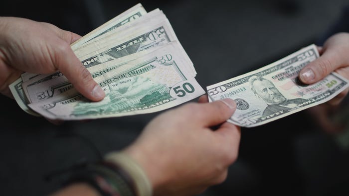 A man and woman exchanging U.S. currency.