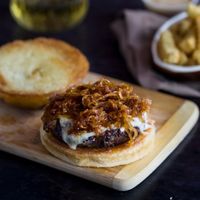 French Onion Burgers. These extra juicy perfectly cooked burgers are topped with melted Gruyere cheese caramelized onions & served over burger buns. #sandwiches #wraps #recipes