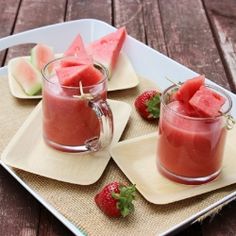 watermelon and strawberry juice in glasses on a tray with slices of watermelon