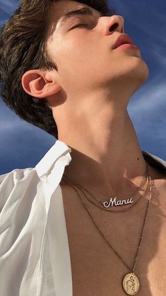 a man wearing a necklace with the word mama engraved on it's chest and his eyes closed