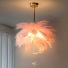 a chandelier with pink feathers hanging from the ceiling