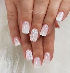 a woman's hand with white and silver nail polishes on her nails, which are