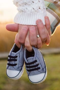 a person holding two pairs of shoes in their hands